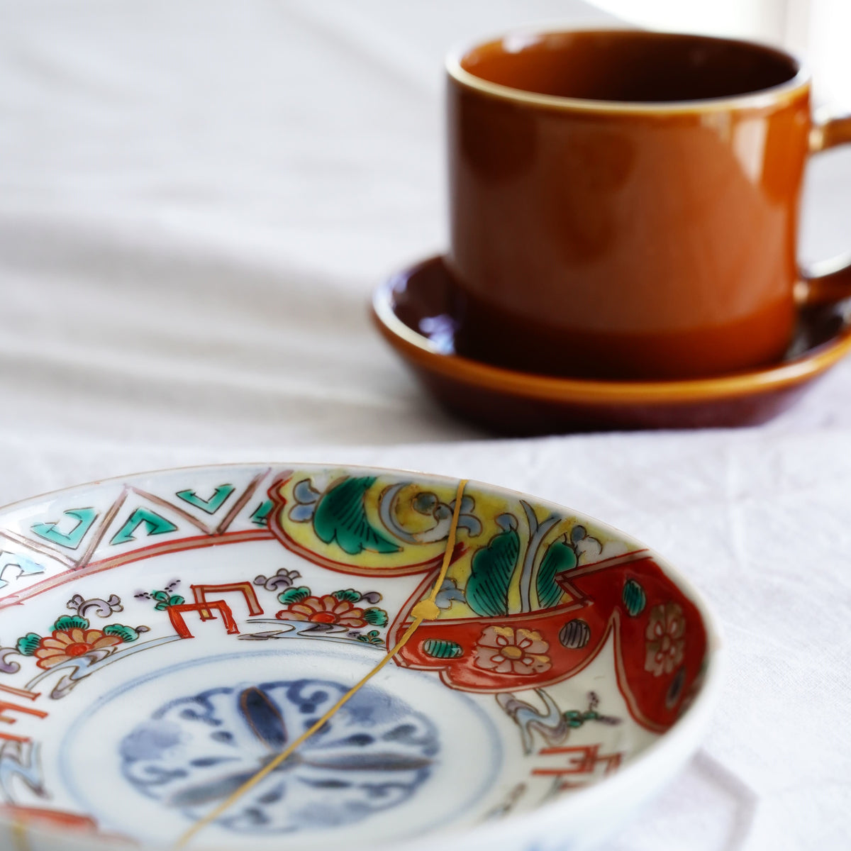 Piattino antico Imari, periodo Meiji – Porcellana giapponese riparata con oro (Kintsugi), decoro ruscello, crisantemi e lespedeza, finitura oro opaco